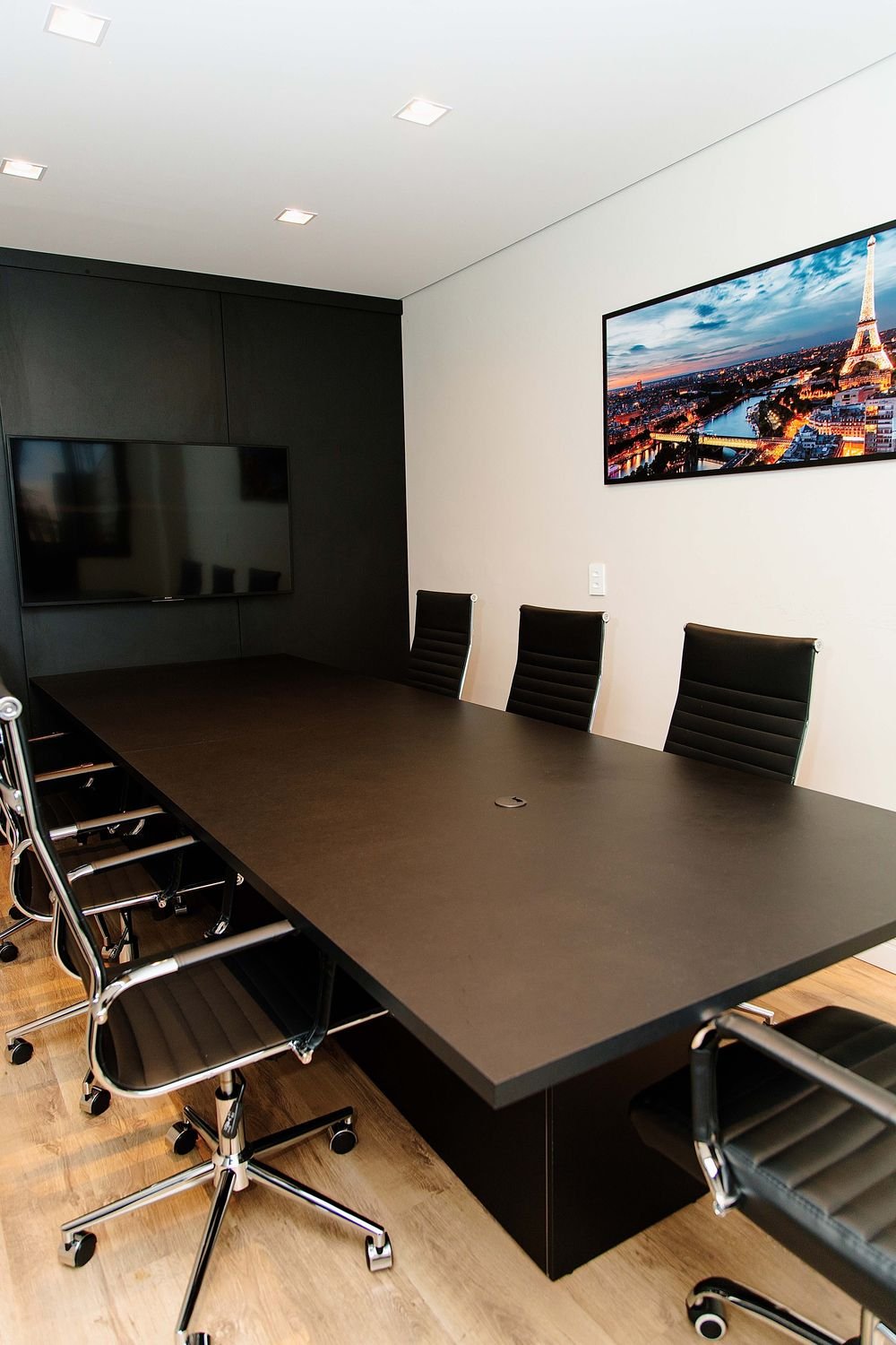 Sala de reuniões do escritório FCR Advogados com mesa para seis lugares e televisor